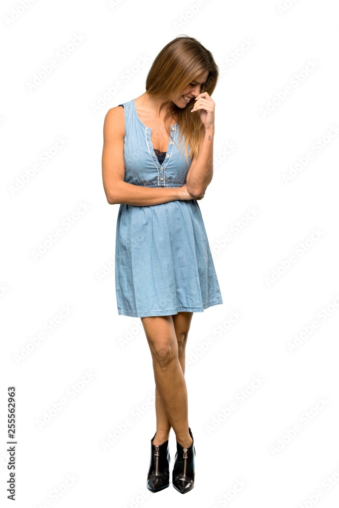 A full-length shot of a Blonde woman with jean dress Happy and smiling over isolated white background A full-length shot of a Blonde woman with jean dress Happy and smiling over isolated white background