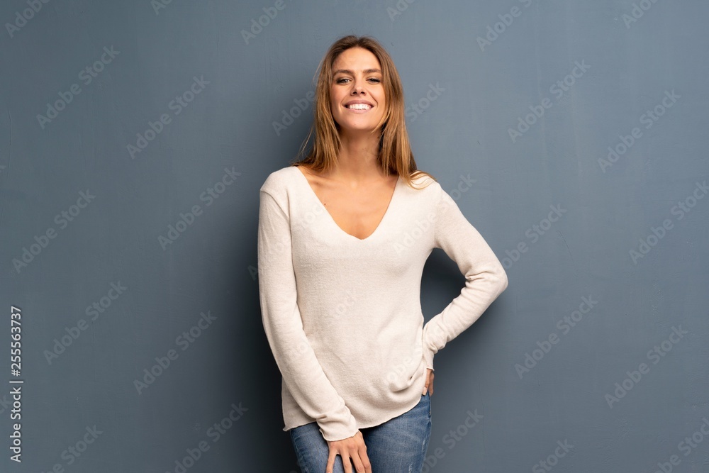 Blonde woman over grey background laughing looking to the front Blonde woman over grey background laughing looking to the front
