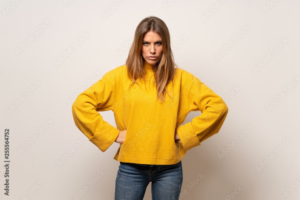 Woman with yellow sweater over isolated wall angry Woman with yellow sweater over isolated wall angry