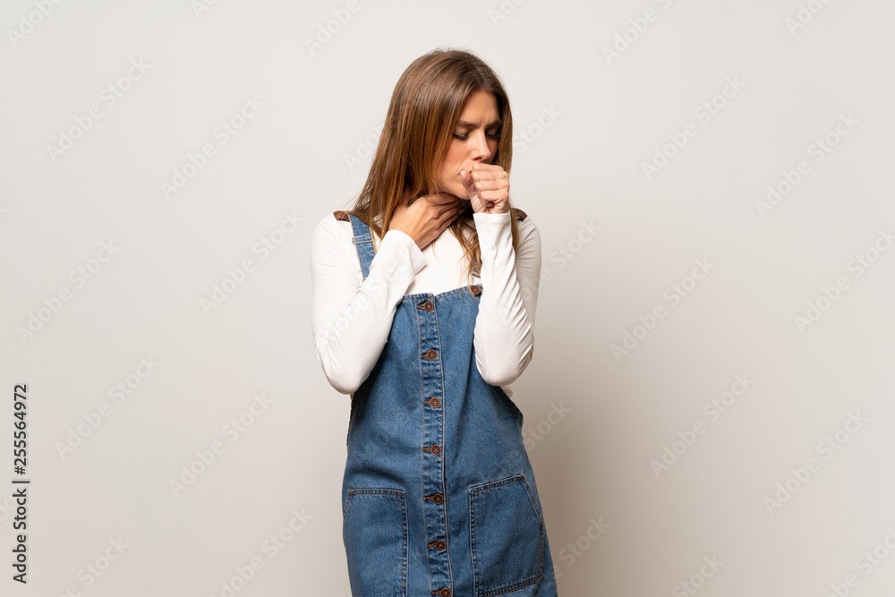 Beautiful woman over isolated white wall is suffering with cough and feeling bad Beautiful woman over isolated white wall is suffering with cough and feeling bad