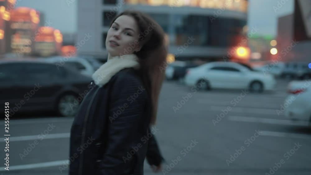 Young woman make a follow me gesture walking in the evening city Young woman make a follow me gesture walking in the evening city