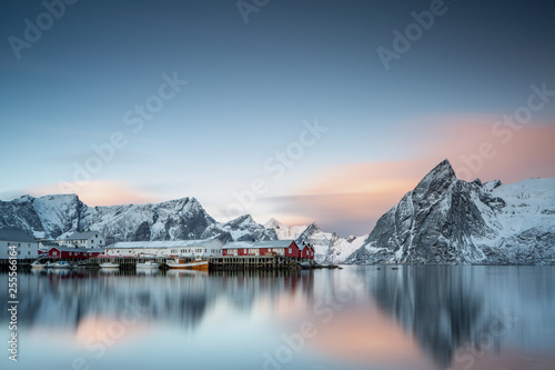 Beautiful traditional fishing red rorbuer huts in Hamnoy village and Olstinden peak. Lofoten Islands, Norway, Scandinavia