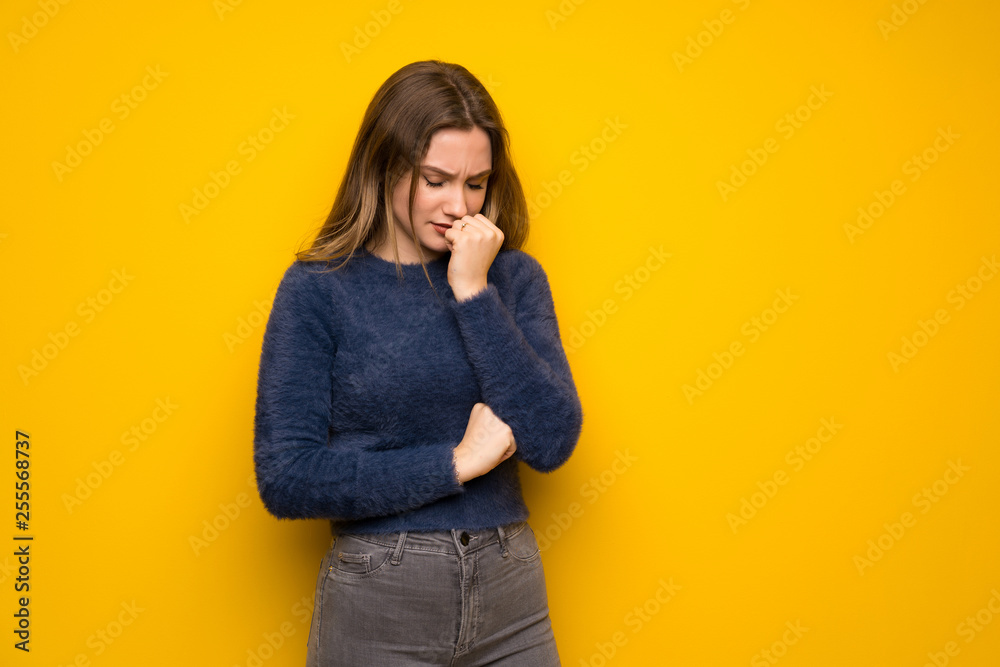 Teenager girl over yellow wall having doubts Teenager girl over yellow wall having doubts