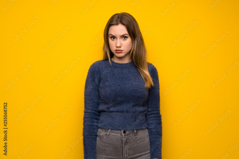 Teenager girl over yellow wall with sad and depressed expression Teenager girl over yellow wall with sad and depressed expression
