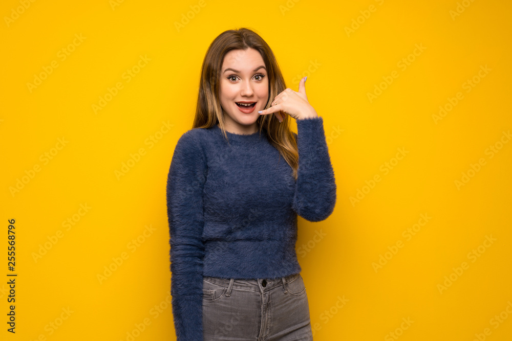 Teenager girl over yellow wall making phone gesture. Call me back sign Teenager girl over yellow wall making phone gesture. Call me back sign