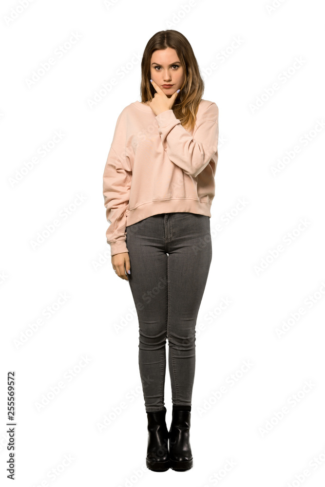 A full-length shot of a Teenager girl with pink sweater thinking over isolated white background A full-length shot of a Teenager girl with pink sweater thinking over isolated white background