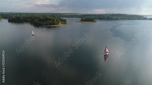 Two yachts floats on water surface in the lake. Landscape with sailing yachts, sailing regatta in the water bay.