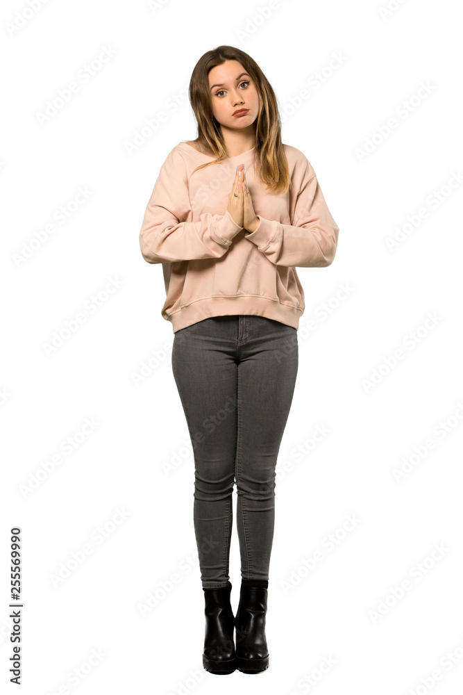 A full-length shot of a Teenager girl with pink sweater keeps palm together. Person asks for something over isolated white background A full-length shot of a Teenager girl with pink sweater keeps palm together. Person asks for something over isolated white background