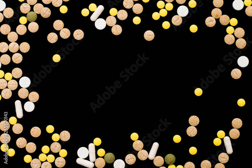 Assorted pharmaceutical medicine pills, tablets and capsules on black background. Creative idea. Drugs. Sad. Die. Illness.