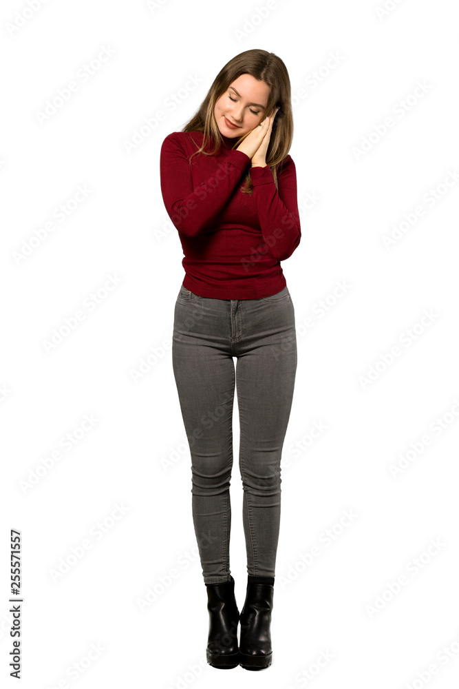 A full-length shot of a Teenager girl with turtleneck making sleep gesture in dorable expression over isolated white background A full-length shot of a Teenager girl with turtleneck making sleep gesture in dorable expression over isolated white background