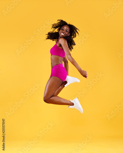 Fototapeta Naklejka Na Ścianę i Meble -  Sporty fit black skin woman, athlete makes fitness exercising on dark background.