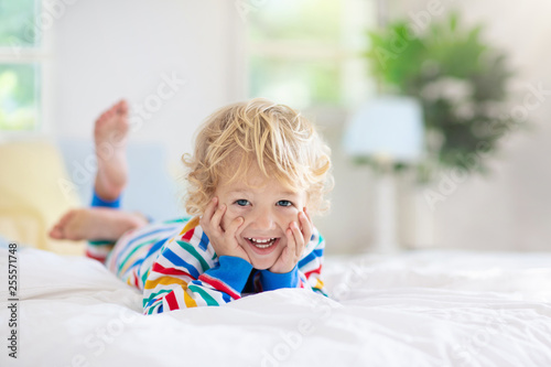 Child playing in bed. Kids room. Baby boy at home.