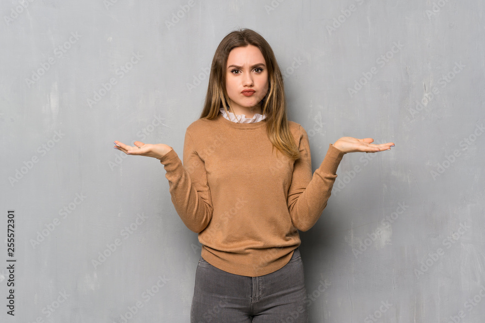 Teenager girl over textured wall unhappy because not understand something Teenager girl over textured wall unhappy because not understand something