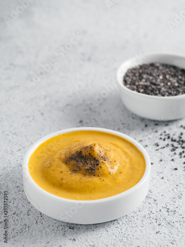 Creamy Cheddar sauce with chia seeds on gray background.Ideas and recipe for healthy diet or vegan food.Homemade Chia Cheeze Sauce for snacks tacos nachos dipping mac-n-cheese base for pizza.Copyspace