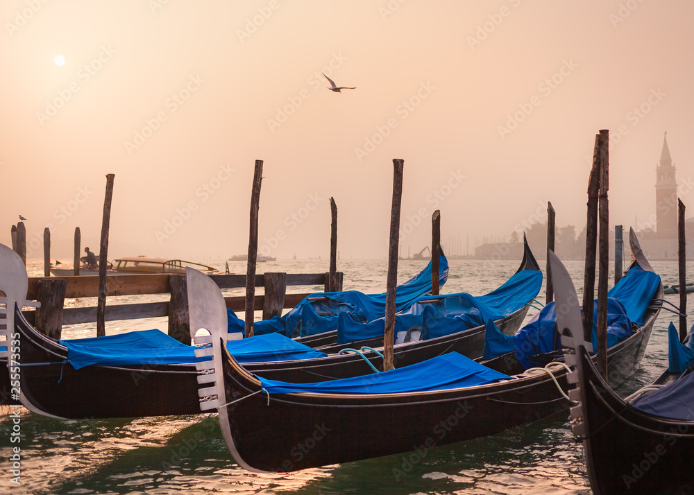 Venetian foggy morning and gondolas on the pier