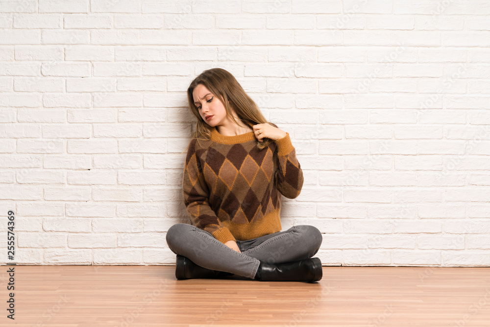 Teenager girl sitting on the floor with tired and sick expression Teenager girl sitting on the floor with tired and sick expression
