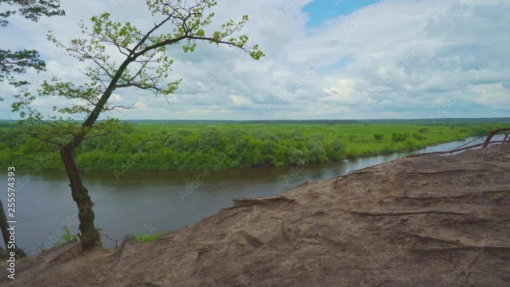 Beautiful blue sky with running clouds over river. Beautiful landscape on the background of blue sky. Time lapse video. 4k footage. Trees' roots. Beautiful blue sky with running clouds over river. Beautiful landscape on the background of blue sky. Time lapse video. 4k footage. Trees' roots.