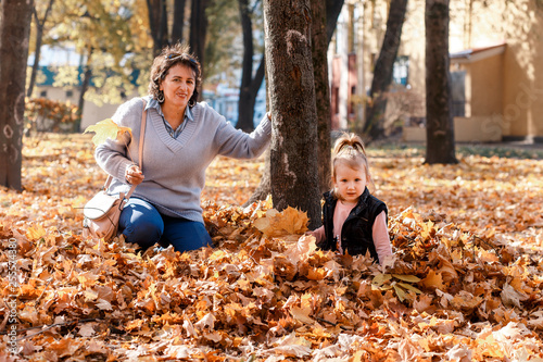 A girl with her granny walking and having fun outside in autumn