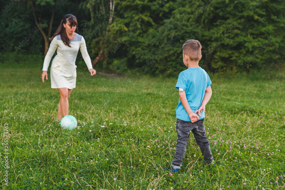 mother play with son in ball at green field. mother play with son in ball at green field.