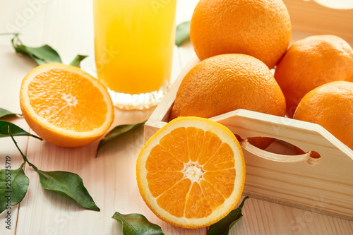 glass of orange juice and orange fruits on wooden background