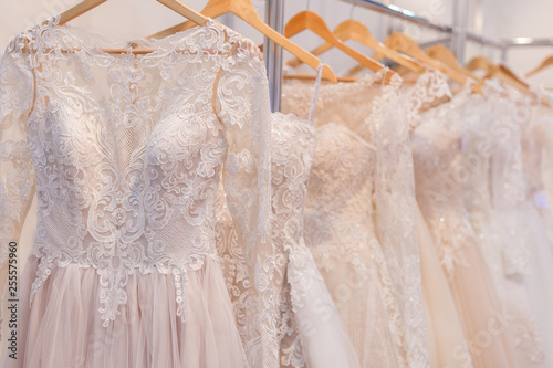 Beautiful lace wedding dresses on hangers in the showroom.