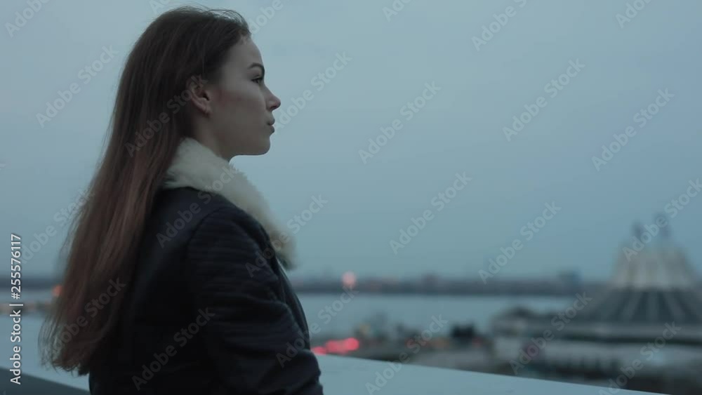 Young woman relaxing and looks forward to evening city scape Young woman relaxing and looks forward to evening city scape