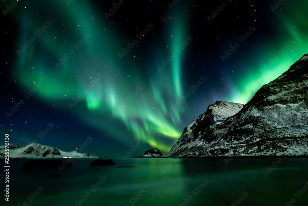 Beautiful green Northern Lights at Haukland Beach on the Lofoten Islands in Norway