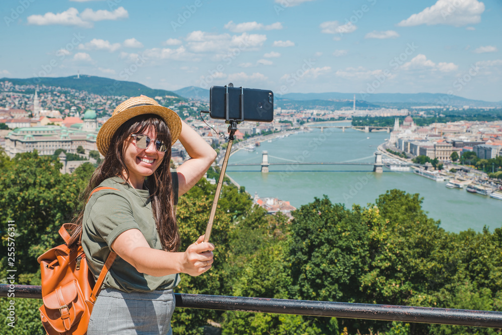 smiling cheerful woman in sunglasses taking selfie. budapest city on background. travel concept. copy space