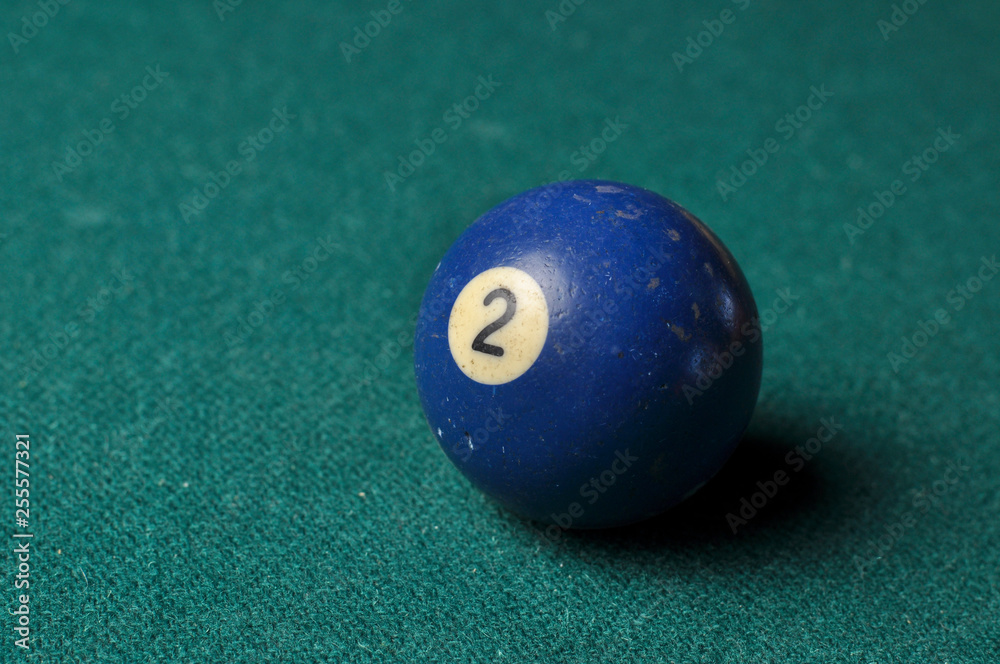 Old billiard ball number 2 blue color on green billiard table, copy space