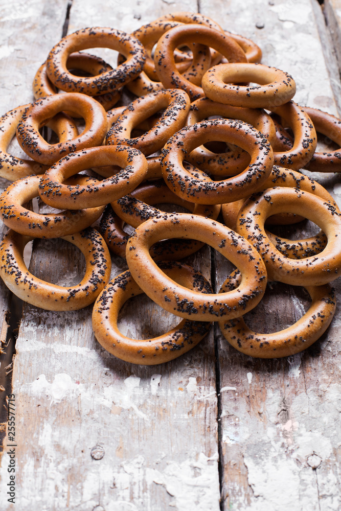 Photo of delicious bagels sprinkled with poppy seeds. Light wooden background Photo of delicious bagels sprinkled with poppy seeds. Light wooden background