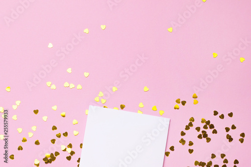 White gretting card with golden love confetti on pink color paper background minimal style