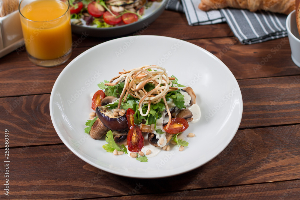 Grilled eggplant salad, tomatoes, mushrooms, cheese sauce, Cecil smoked cheese, fresh herbs. Wooden background