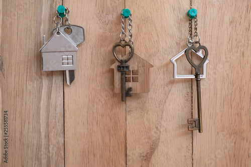 Heart shape house key with home keyring on wood fence background