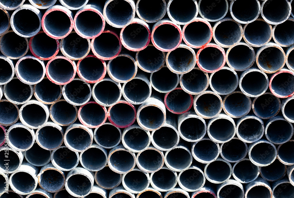 End view on scaffold poles stockpile stacked on storage rack on building construction site End view on scaffold poles stockpile stacked on storage rack on building construction site