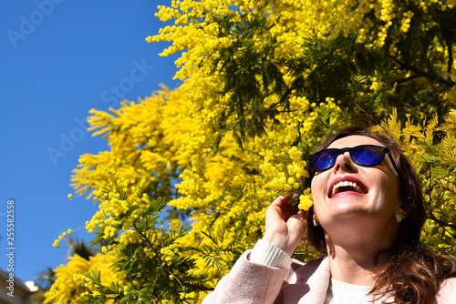 young woman in spring park with mimosas