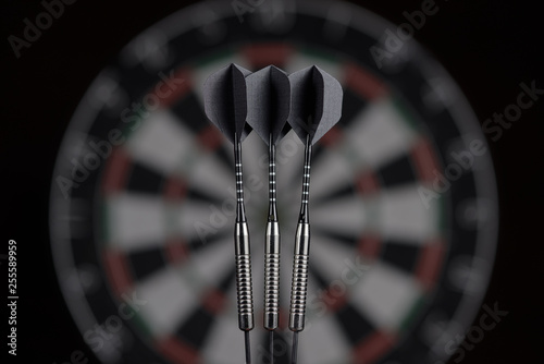 3 darts on dartboard background. dart board blurred photo