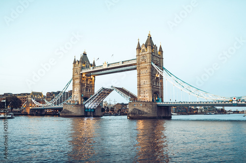 Illuminated Tower Bridge right after the sunset opens to allow a ship to pass