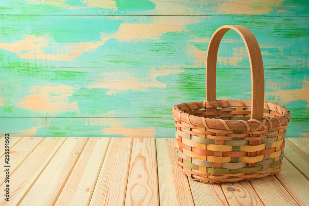 Empty basket on wooden table over colorful background. Empty basket on wooden table over colorful background.