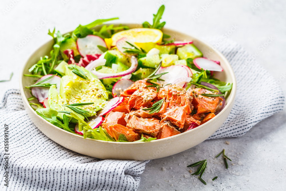 Baked red fish salad with avocado, cucumber, radish and arugula in white plate. Baked red fish salad with avocado, cucumber, radish and arugula in white plate.