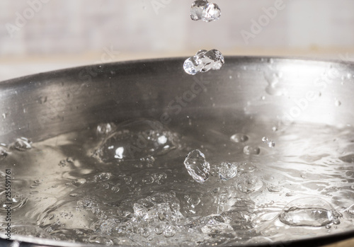 Boiling water in a metal pan close-up