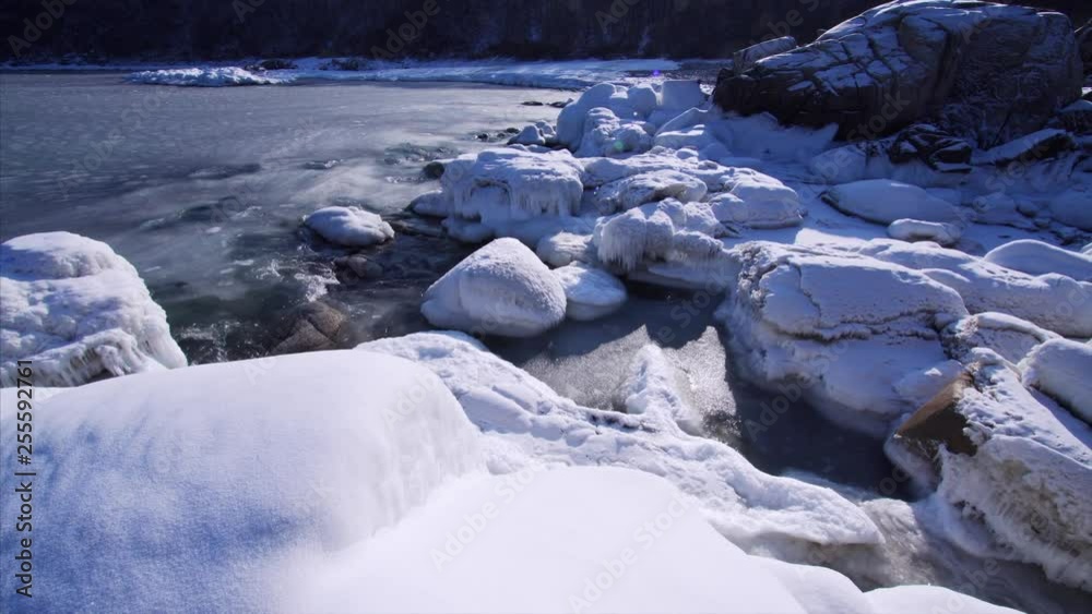 Static view of cold sea waves breaking at snowy stones. Marine biospheric reservation at Far East of Russia Static view of cold sea waves breaking at snowy stones. Marine biospheric reservation at Far East of Russia