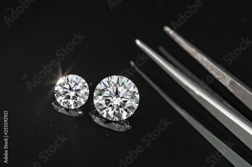 Compared 1.00 and 2.50 carat size diamonds on black background