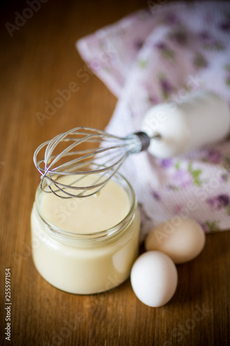homemade mayonnaise in a glass jar on a wooden