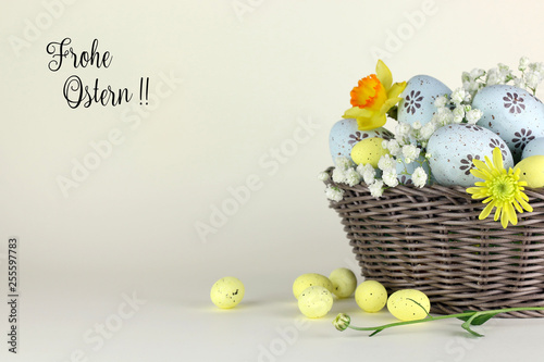 Cestino con Uova di Pasqua e fiori con tag su uno sfondo chiaro