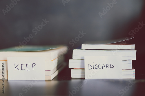 selecting which books to keep and which to discard or donate, decluttering concept