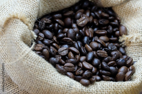 In selective focus of plenty roasted coffee beans in a brown bag