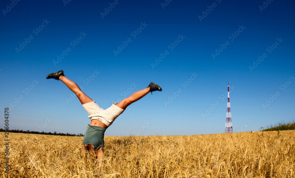 Female with foots up making acrobatic on wheat field Female with foots up making acrobatic on wheat field