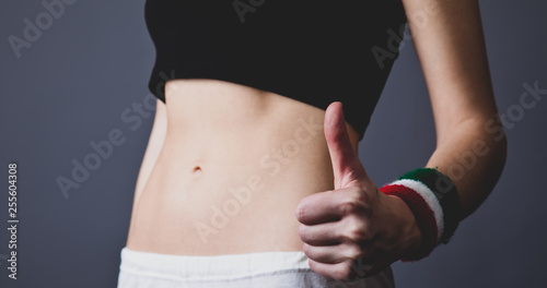 Beautiful and strong womans abs show hand OK