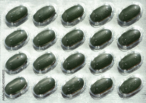 Rows of Green Medicine Tablets in Tin Blister Packs