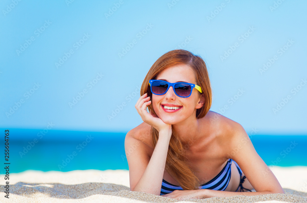 Redhead girl on the beach in spring time. Redhead girl on the beach in spring time.